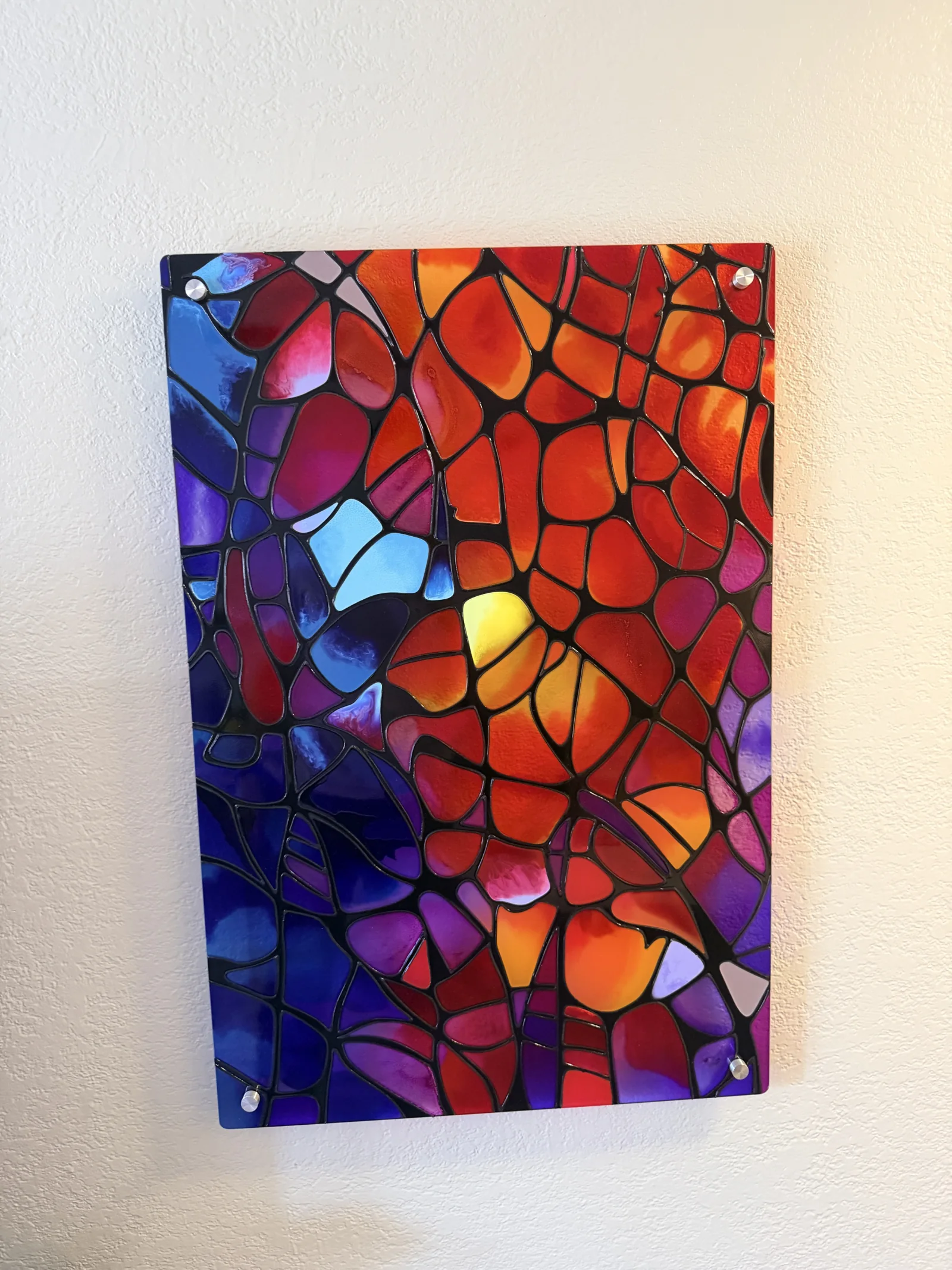 Ember Lattice mounted on silver standoffs against a pale wall, lit by warm side light.
