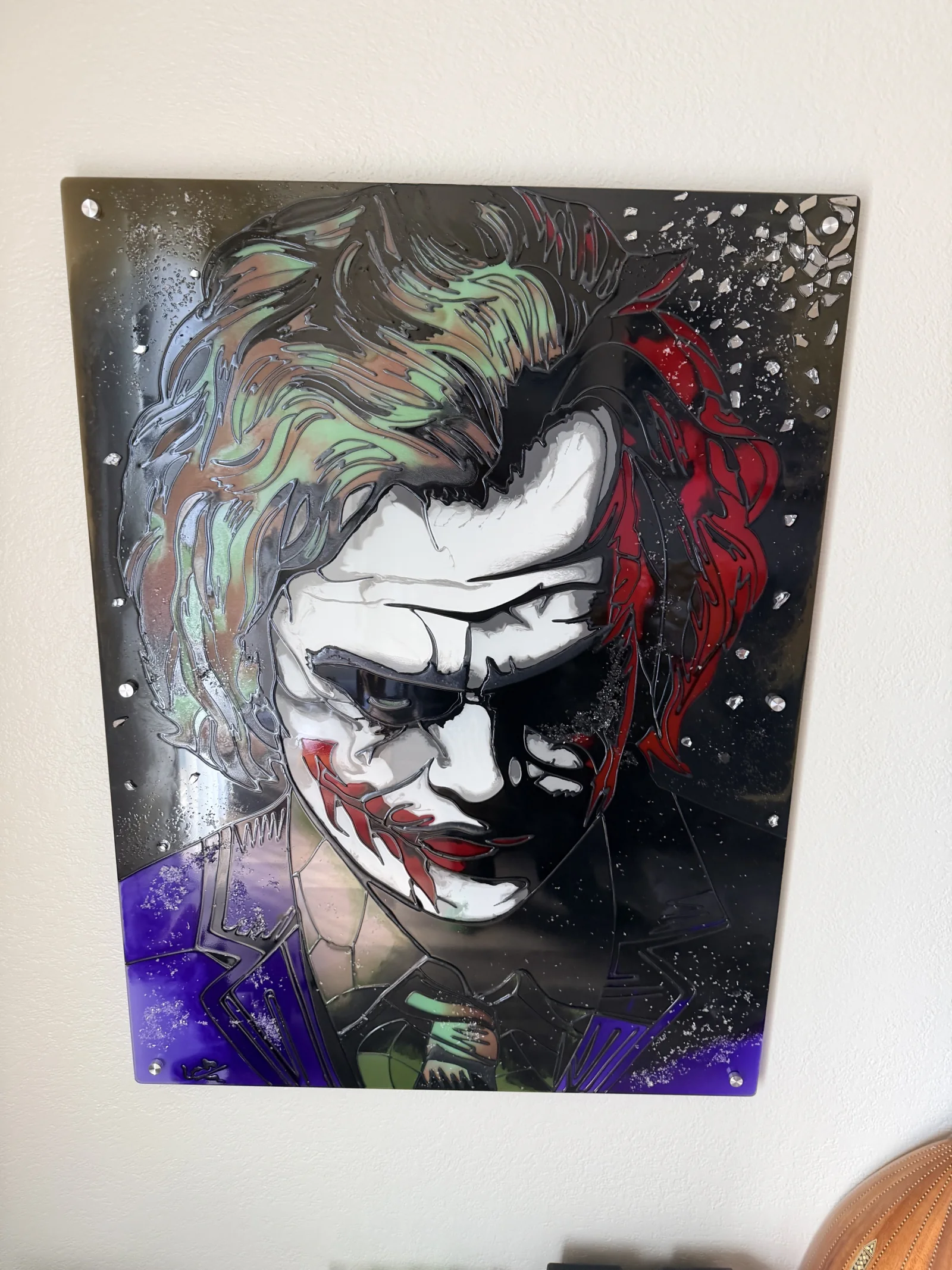A close installed view of The Joker showing green hair, red shadows, violet lapels, and crushed-glass detail.